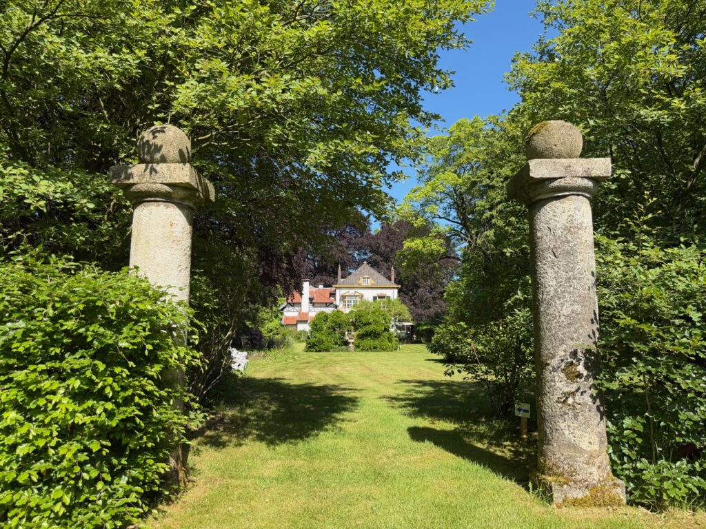 Kolthoorn, rotstuin pilaren met een doorkijk naar het huis